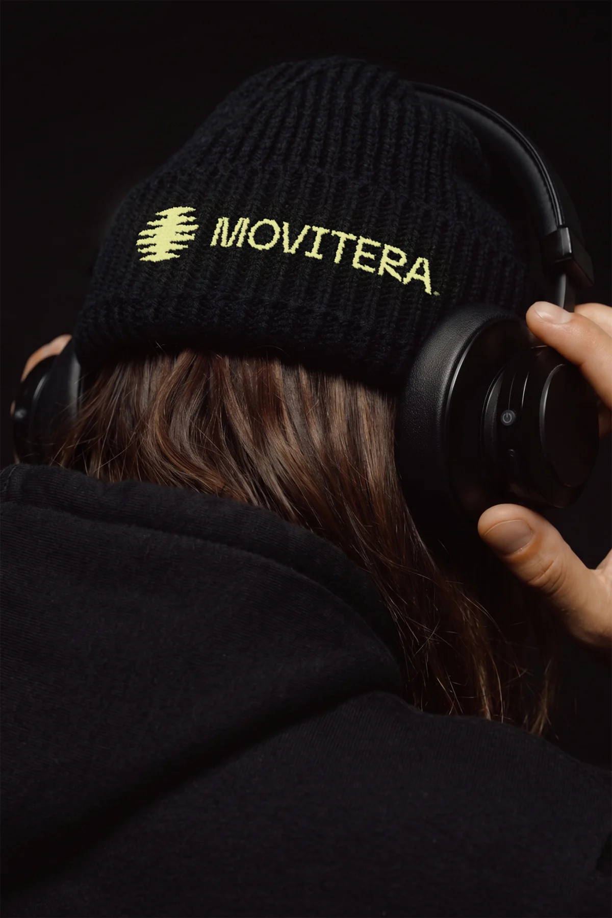 Gorro preto com o símbolo amarelo da Movitera bordado.