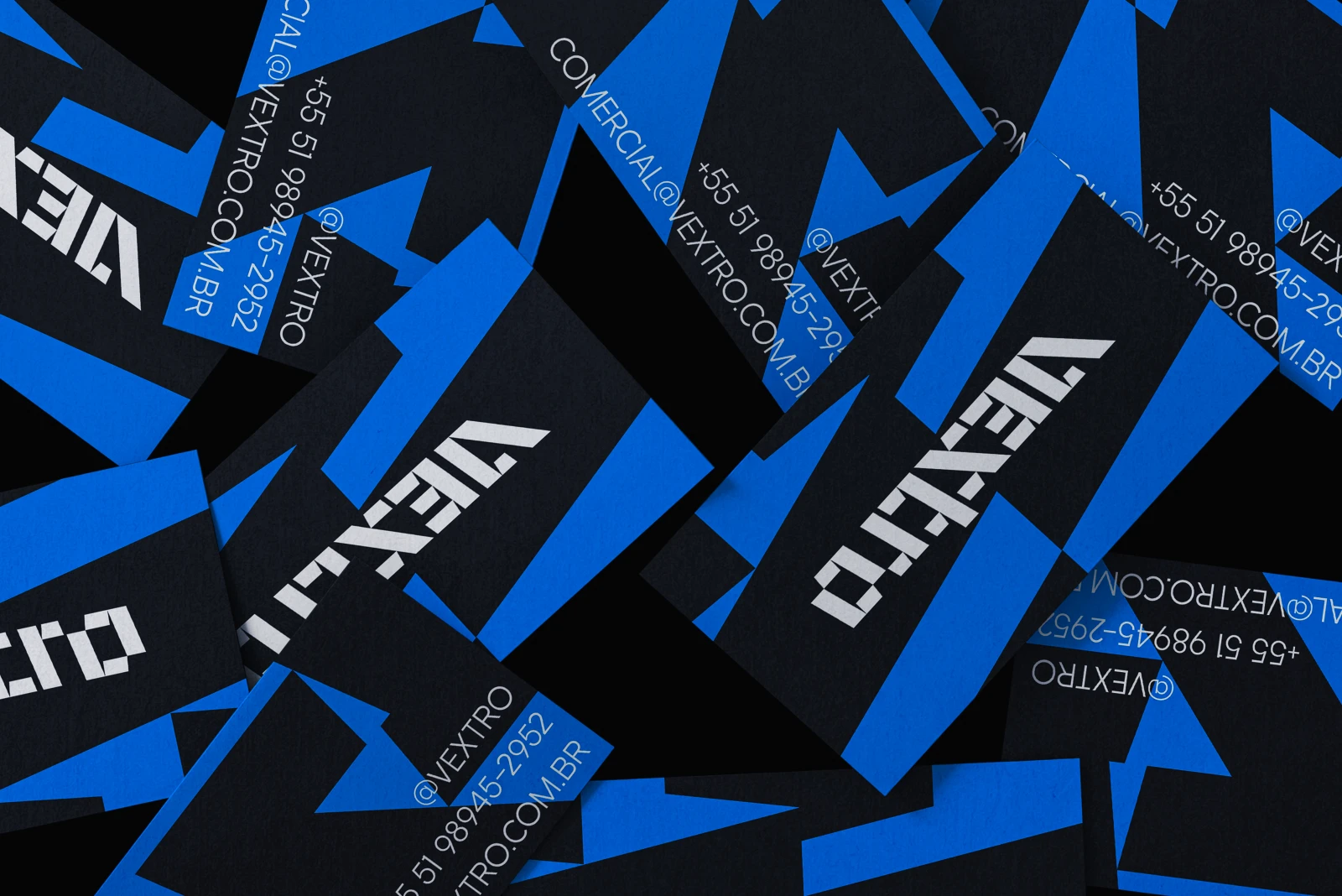 Cartões de visita da Vextro espalhados em preto e azul.