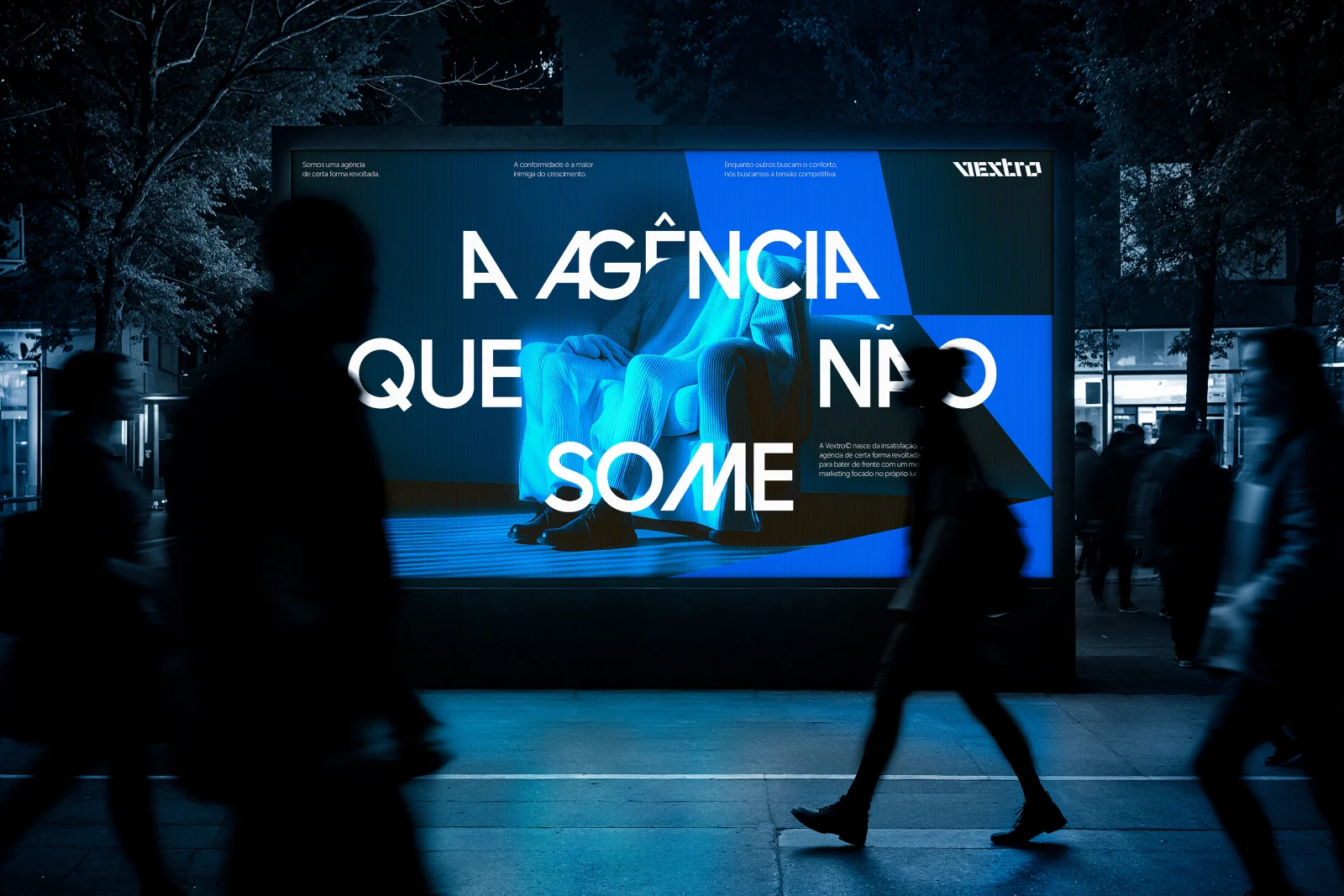 Outdoor iluminado à noite com a frase "A agência que não some".