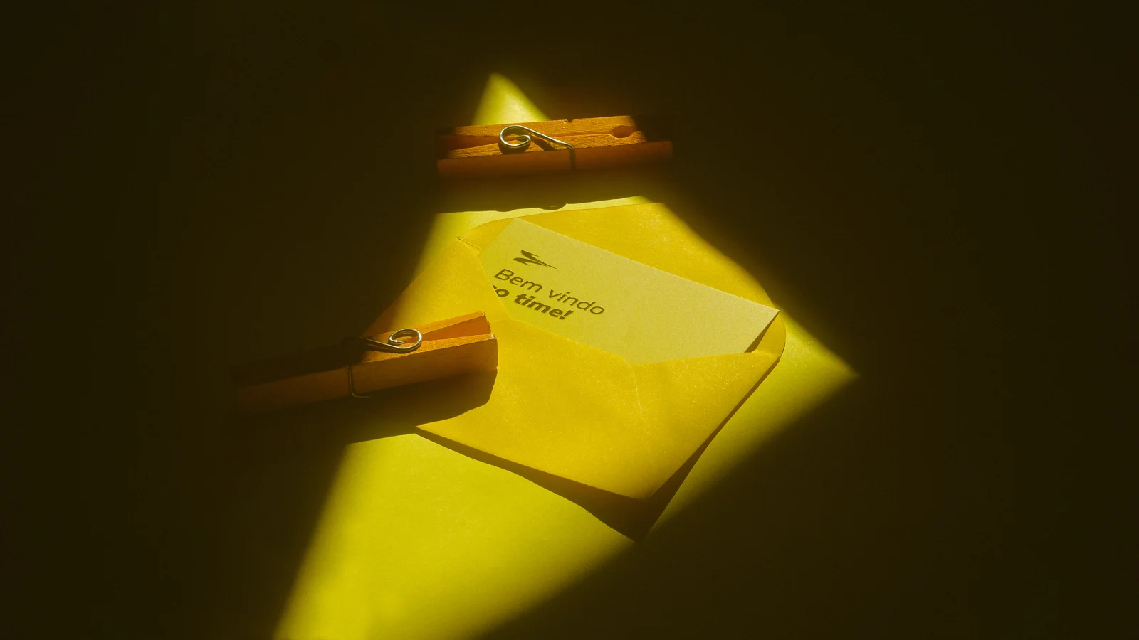 Envelope amarelo com um cartão de boas-vindas escrito "Bem vindo ao time!".