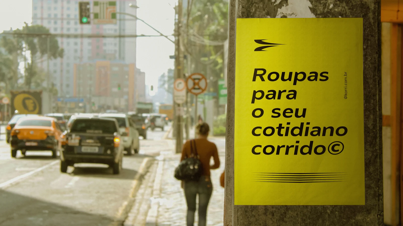 Lambe-lambe amarelo em um poste com o texto "Roupas para o seu cotidiano corrido".