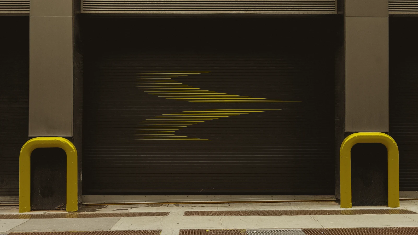 Símbolo da Korri pintado em amarelo sobre uma porta de aço preta.